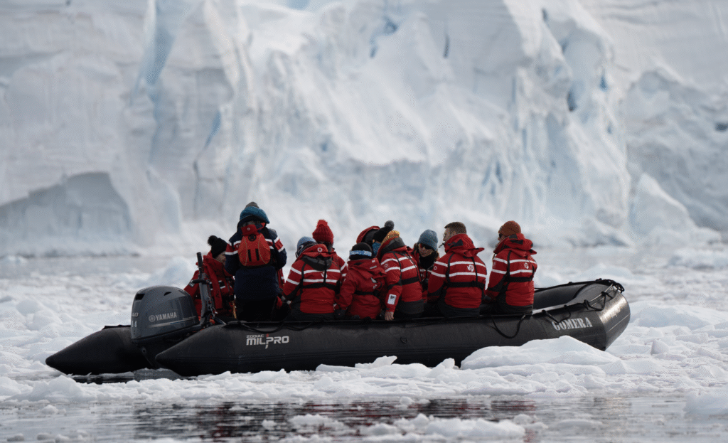 Zodiac cruise from Seaventure with people in red jackets exploring Antarctica's icy landscape by inflatable boat